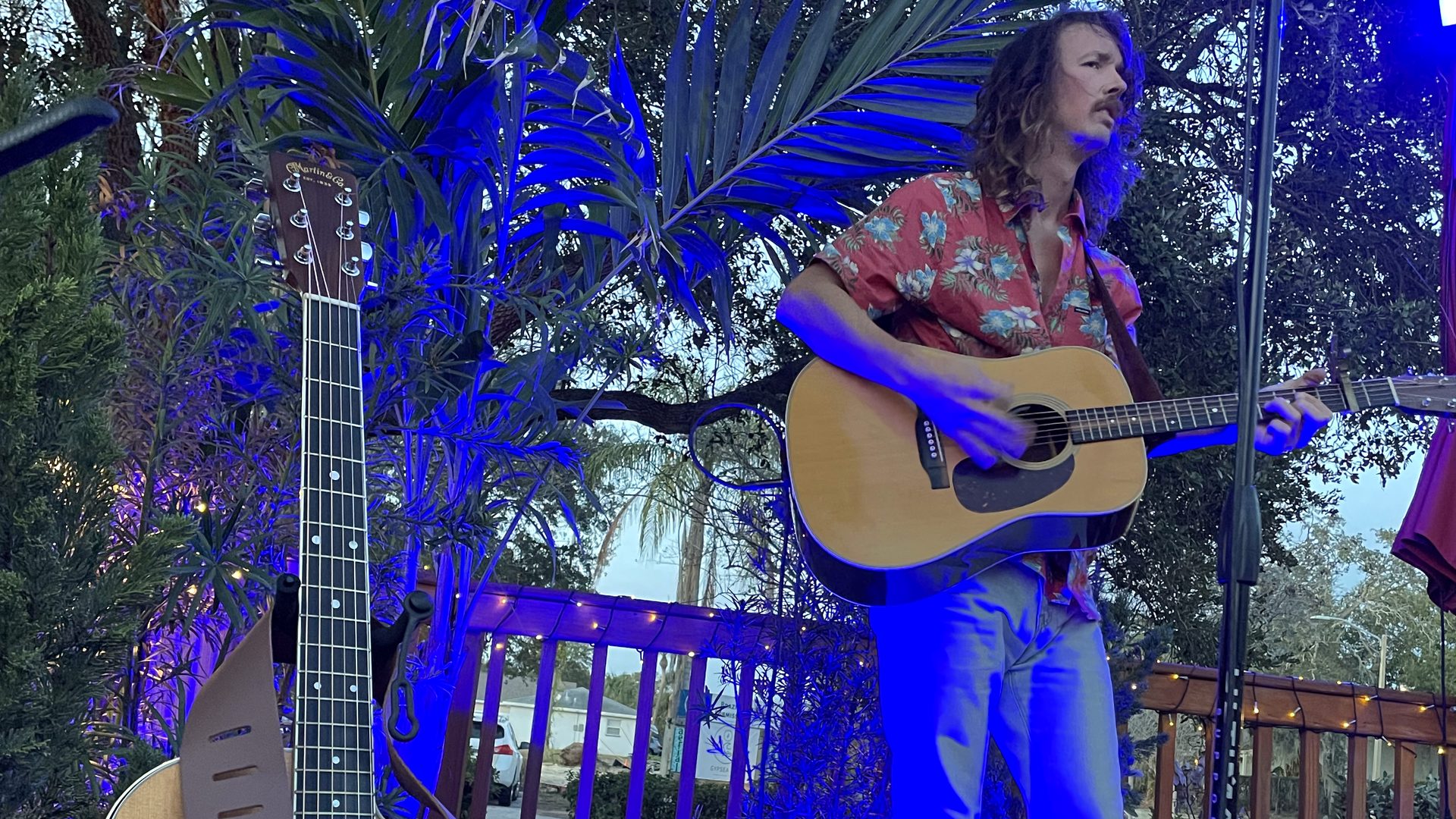 Guitarist playing live on the deck stage under blue lights