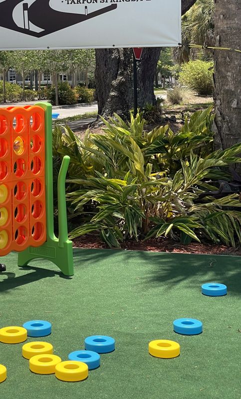 Giant Connect 4 game on artificial turf with yellow and blue pieces